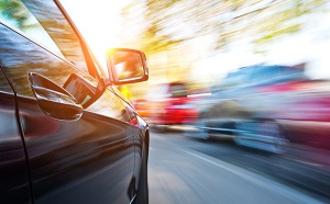 Black car in motion on road