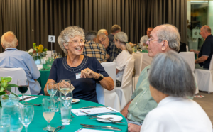 Three people at an award dinner talking and smiling.