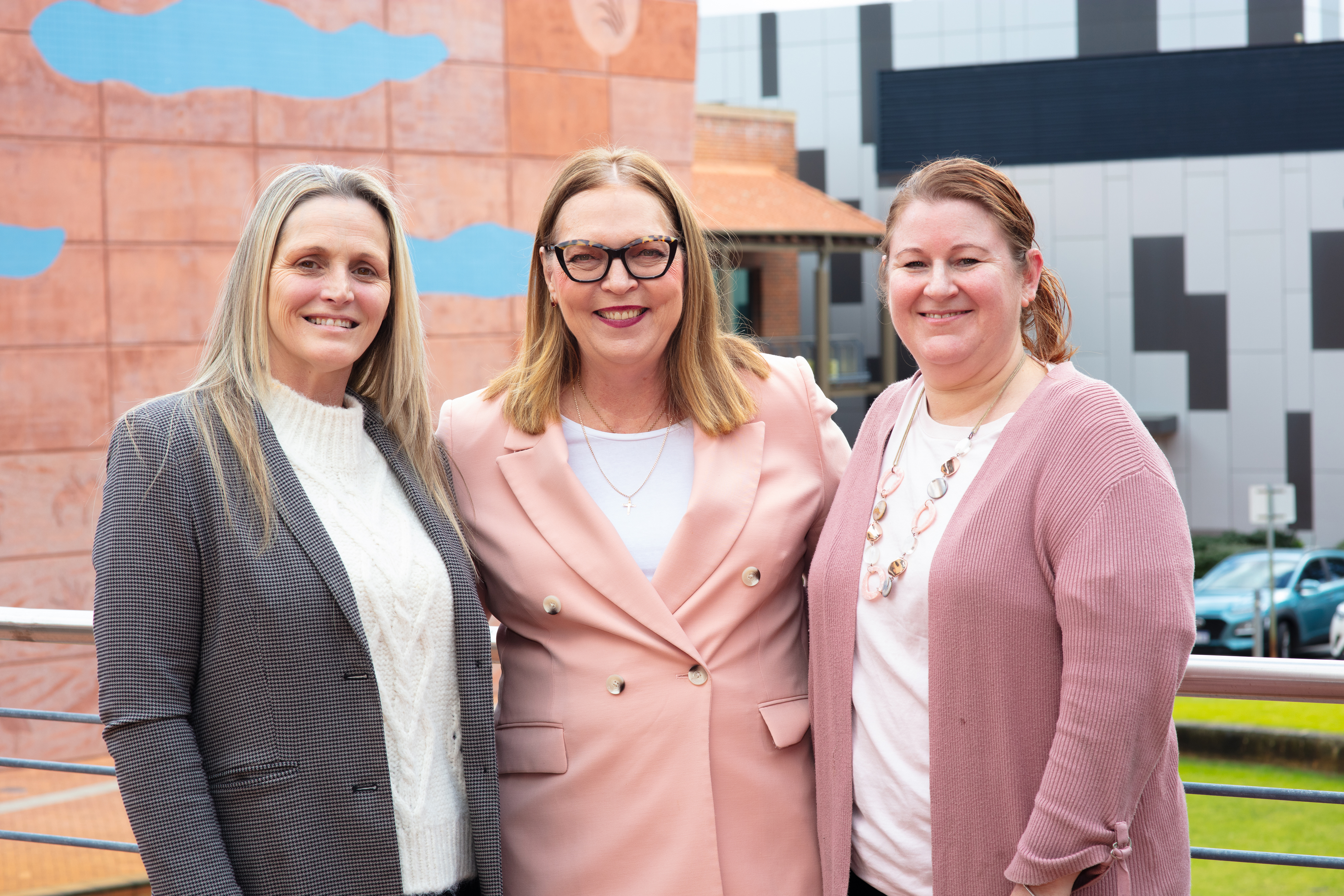 Three women posing for photo and smiling