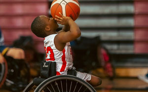 Child in wheelchair playing basketball