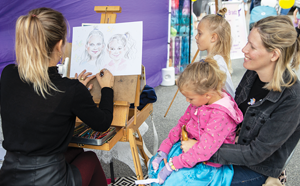 Woman doing a painting of two children