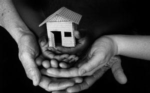 Hands holding cardboard house