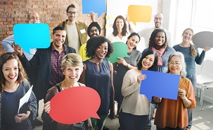 Group of men and women holding speech bubble cards.