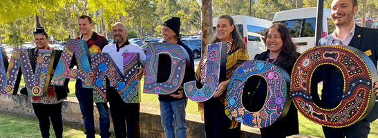 Group of Aboriginal people holding sign saying 'Wandjoo'