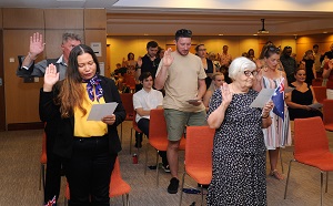 People in a room with chairs raising their hands