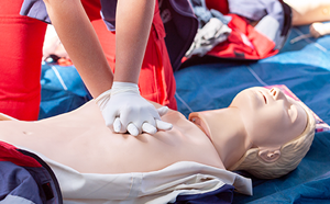Person practicing CPR on dummy
