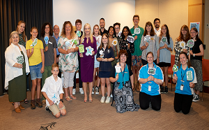 A group of people smiling and holding signs related to environmental action