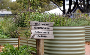 A 'Welcome to Girrawheen Community Garden' sign at the entrance to the garden.