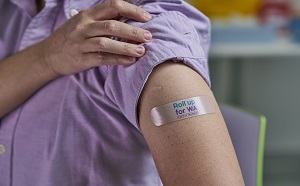 Person displaying their 'Roll up for WA' bandaid after receiving a COVID-19 vaccination.
