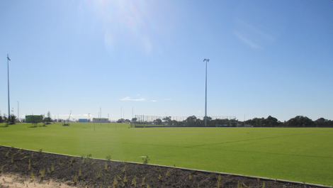 Southern Oval looking north-east towards main sports pavilion pad site across AFL oval, two soccer pitches and baseball diamond backnets