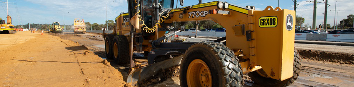 Photo of a road grader and roads being constructed.
