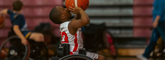 Child in wheelchair playing basketball