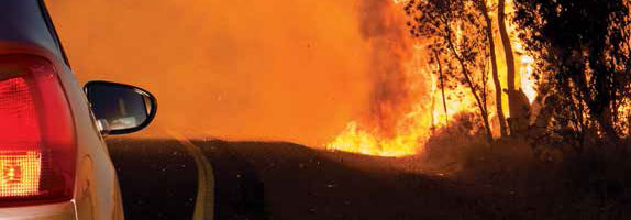 Car driving next to bushfire