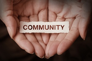 Two hands are cupped together with the word community
