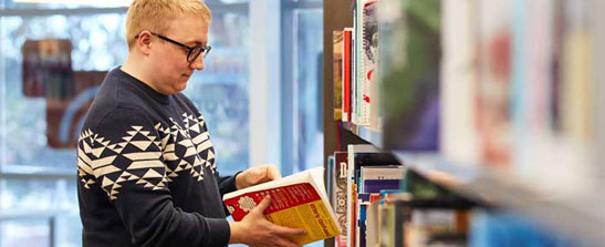 Person browsing books at library