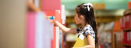 Girl looking for books at library