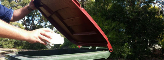 Person disposing of waste in a red-top bin