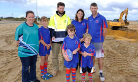 Children and workers at construction of sporting oval