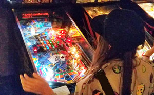 Girl playing pinball