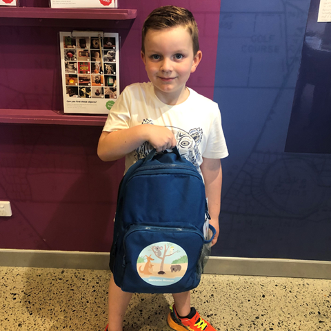 Young boy holding sensory backpack