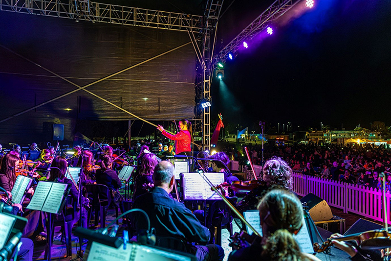 Orchestra playing to large crowd at night