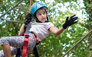 Child climbing tree with equipment