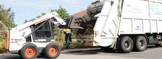 Loader putting kerbside waste into truck