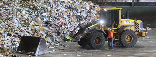 Recycling centre with bulldozer pushing waste