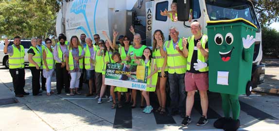 Waste staff and residents next to a waste truck.